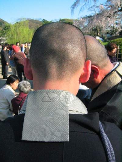 Buddhist monk in black kimono showing the back of the head and collar