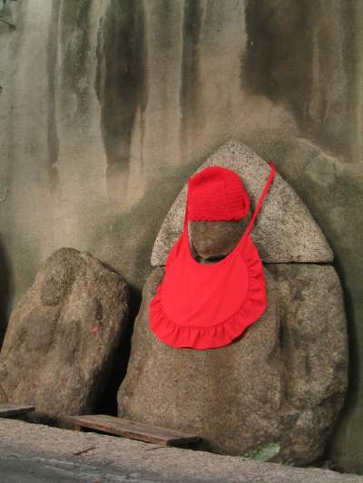 Buddhist Jizo statue wearing a red bib and hat