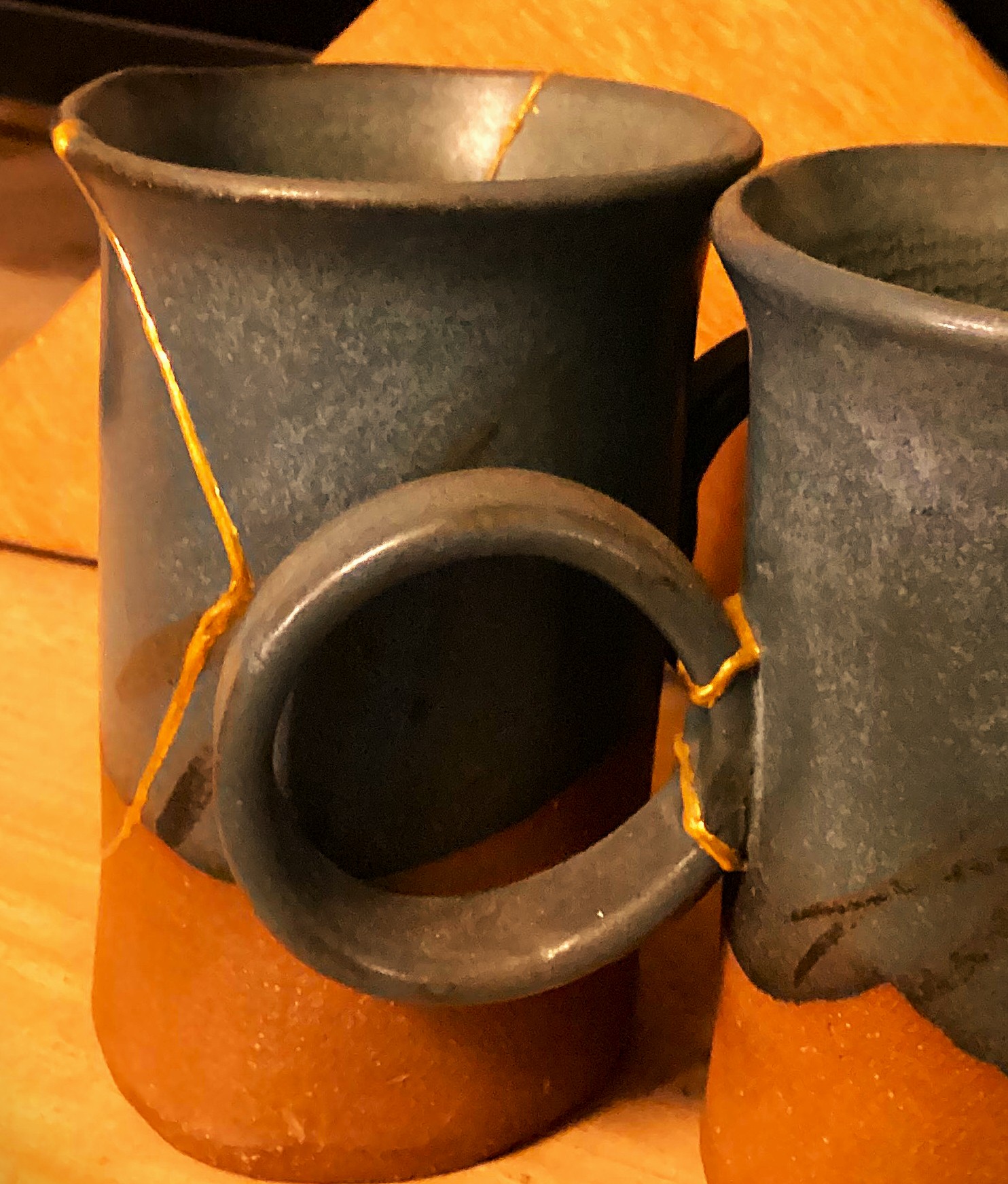 Iconic blue slab mugs by Erika Ropke repaired with gold kintsugi