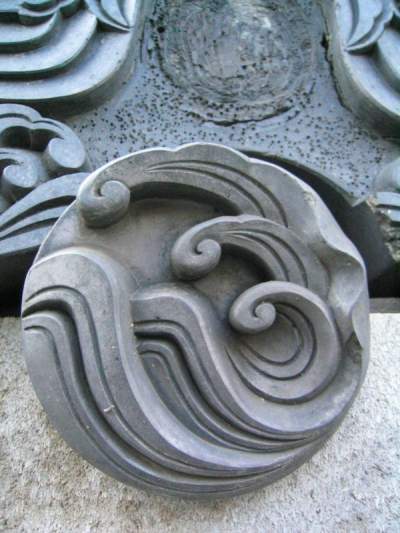 A roof end kyogawara end tile with a wave motif.